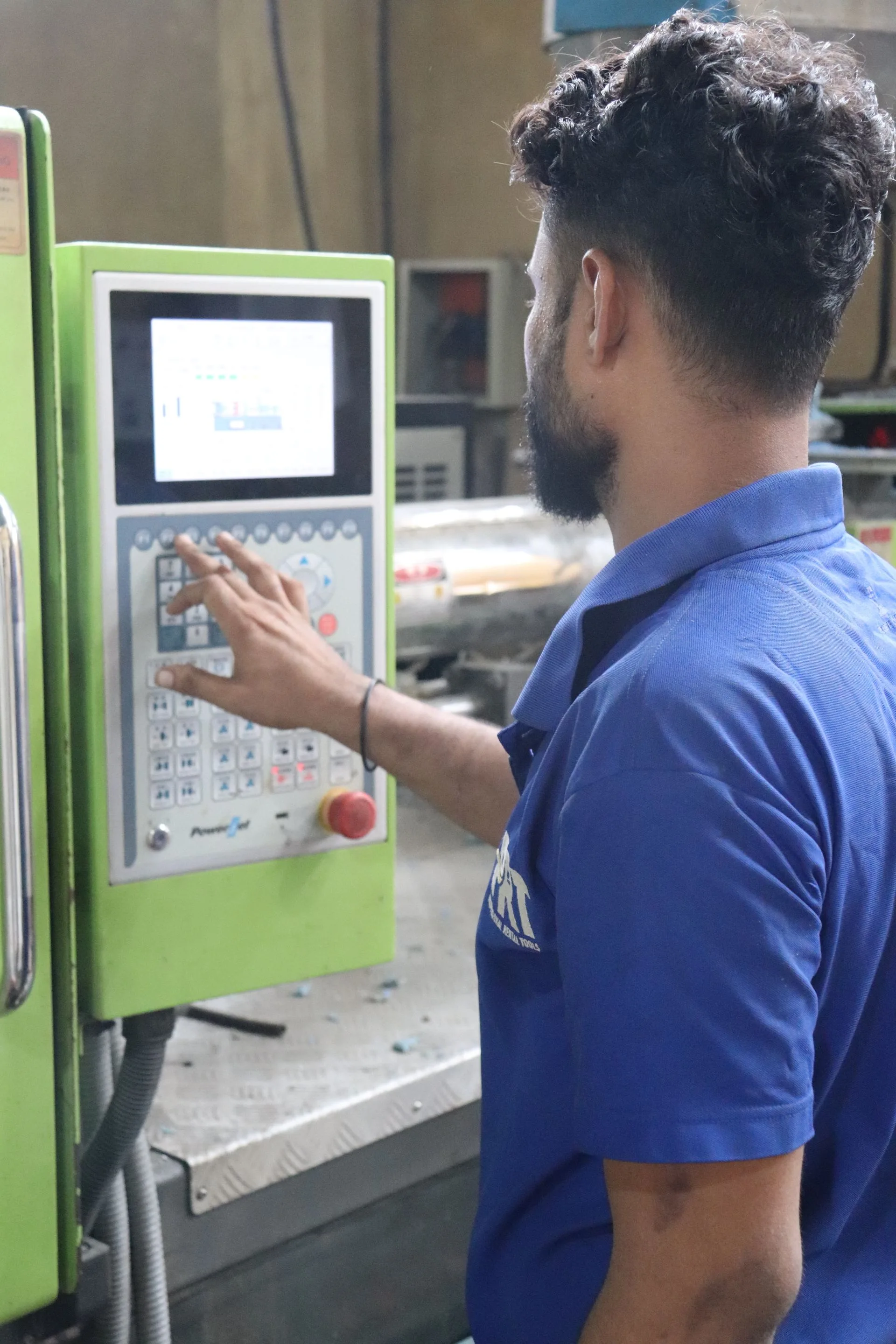 Opérateur utilisant le pupitre d’une machine dans un atelier industriel.