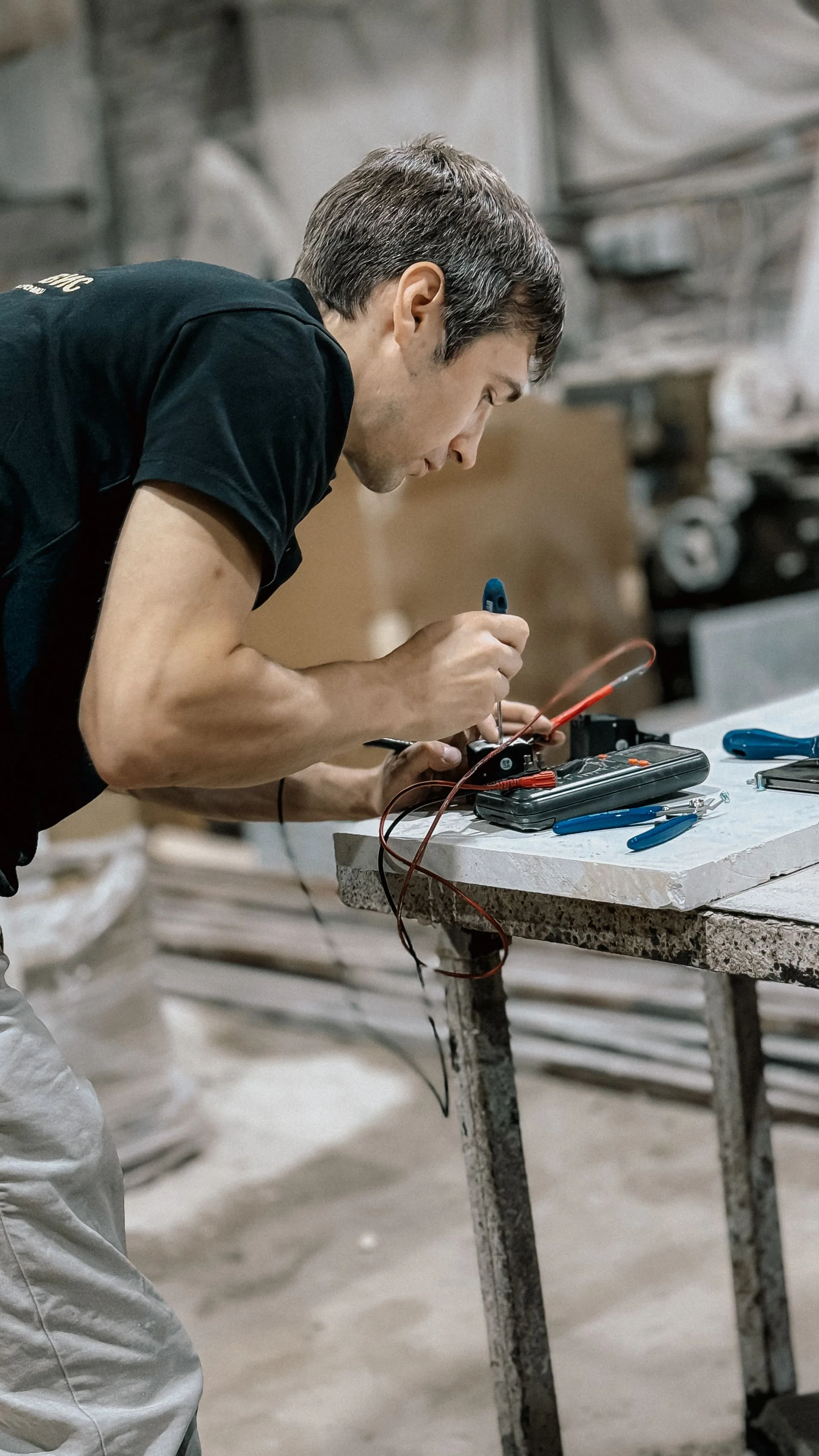 Technicien vérifiant un câblage sur un établi.